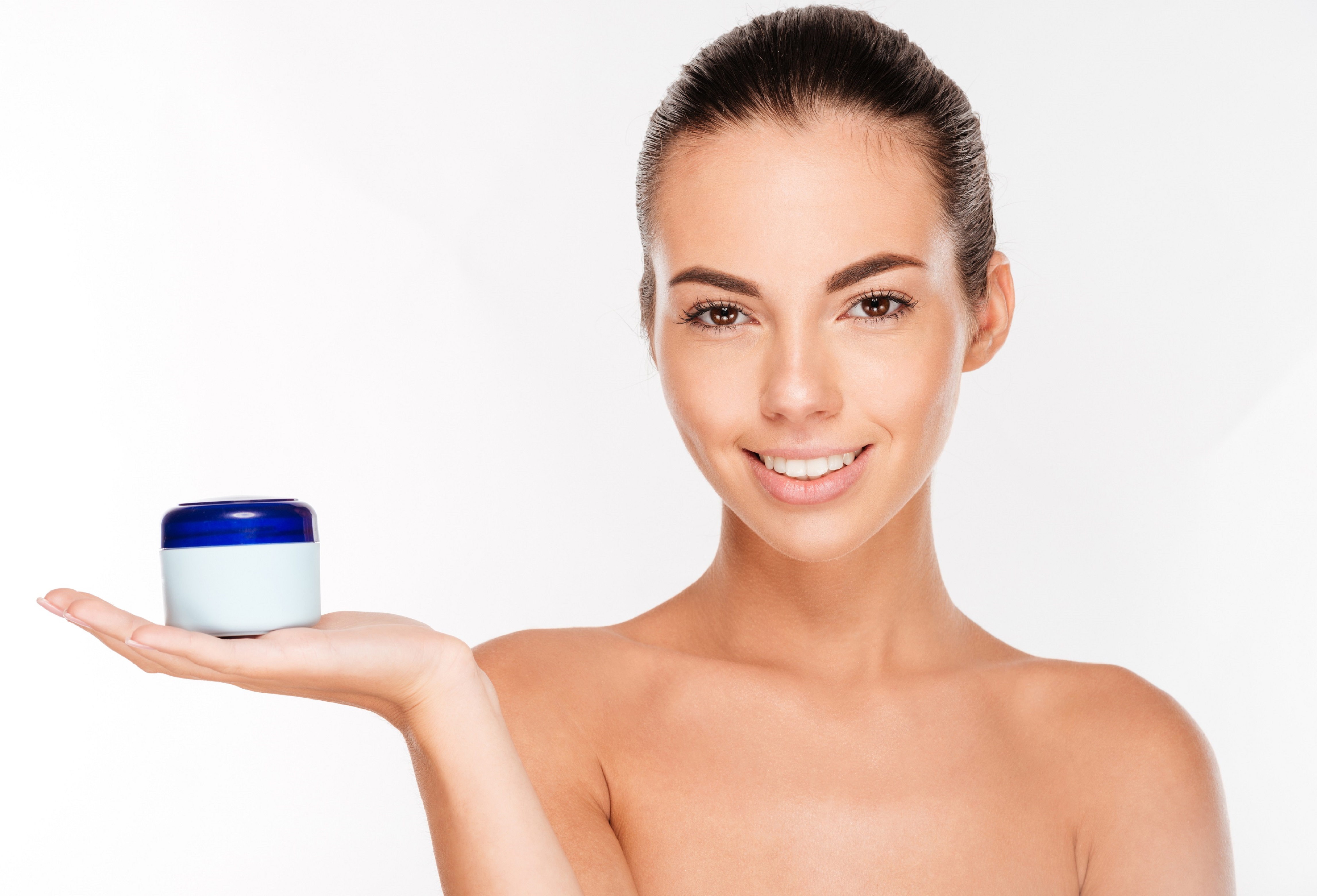 Young beautiful smiling woman with cream bottle Young beautiful smiling woman with cream bottle isolated on white background